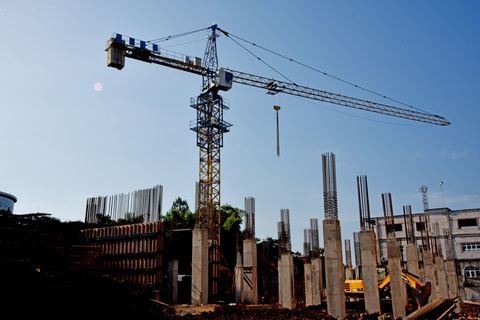 Building under construction with a tower crane and concrete columns